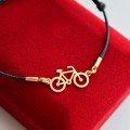 złota bransoletka sznurkowa z rowerem 925